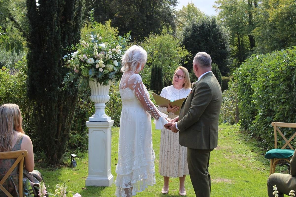 A couple laughing with their guests at a barn wedding ceremony